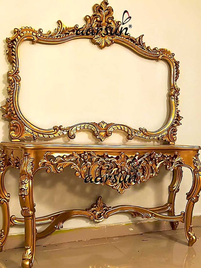 a gold mirror on a console table